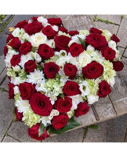 Coeur de roses rouges et fleurs blanches