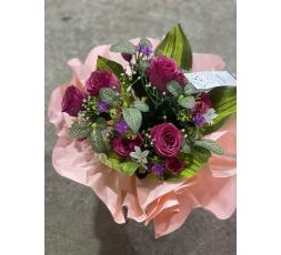 Bouquet rond de fleurs artificielles avec des roses.