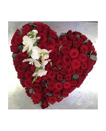 Cœur en roses rouges  avec branches d’orchidées 